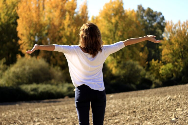 Woman with arms stretched out facing the sun
