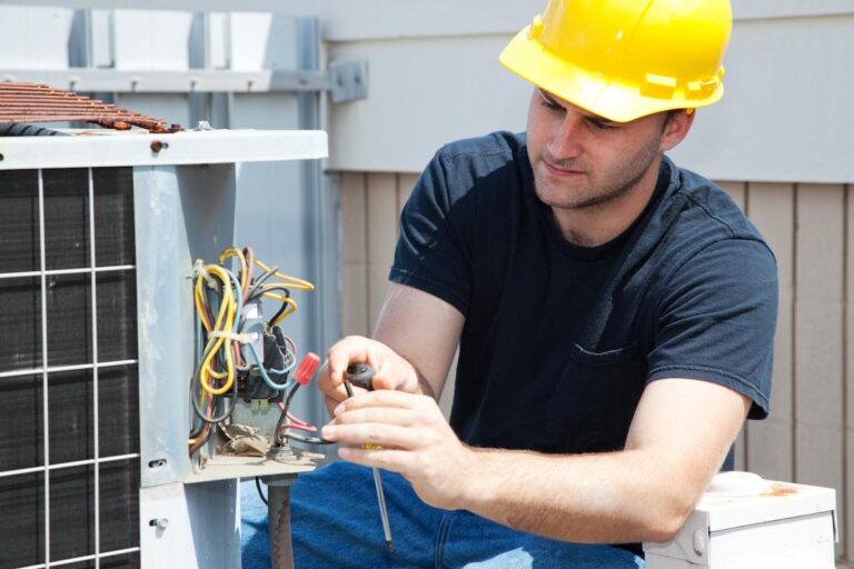 Young repairman fixing an industrial air conditioning compressor.