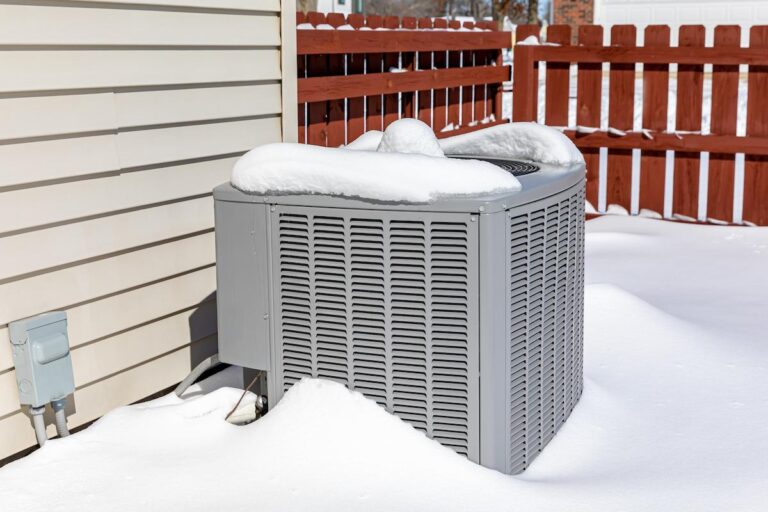 House air conditioning unit covered in snow during winter.
